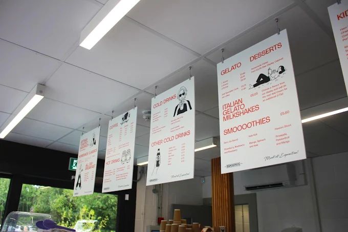 Hanging menu boards showing gelato, desserts, coffee and cold drinks at Esposito's