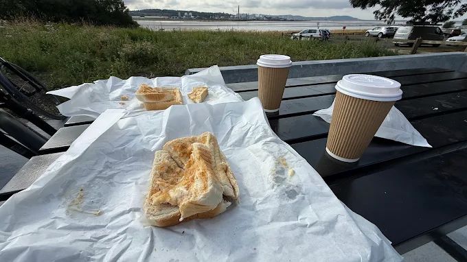 Coffee, sandwiches and pastries served at an outdoor picnic table overlooking the River Mersey